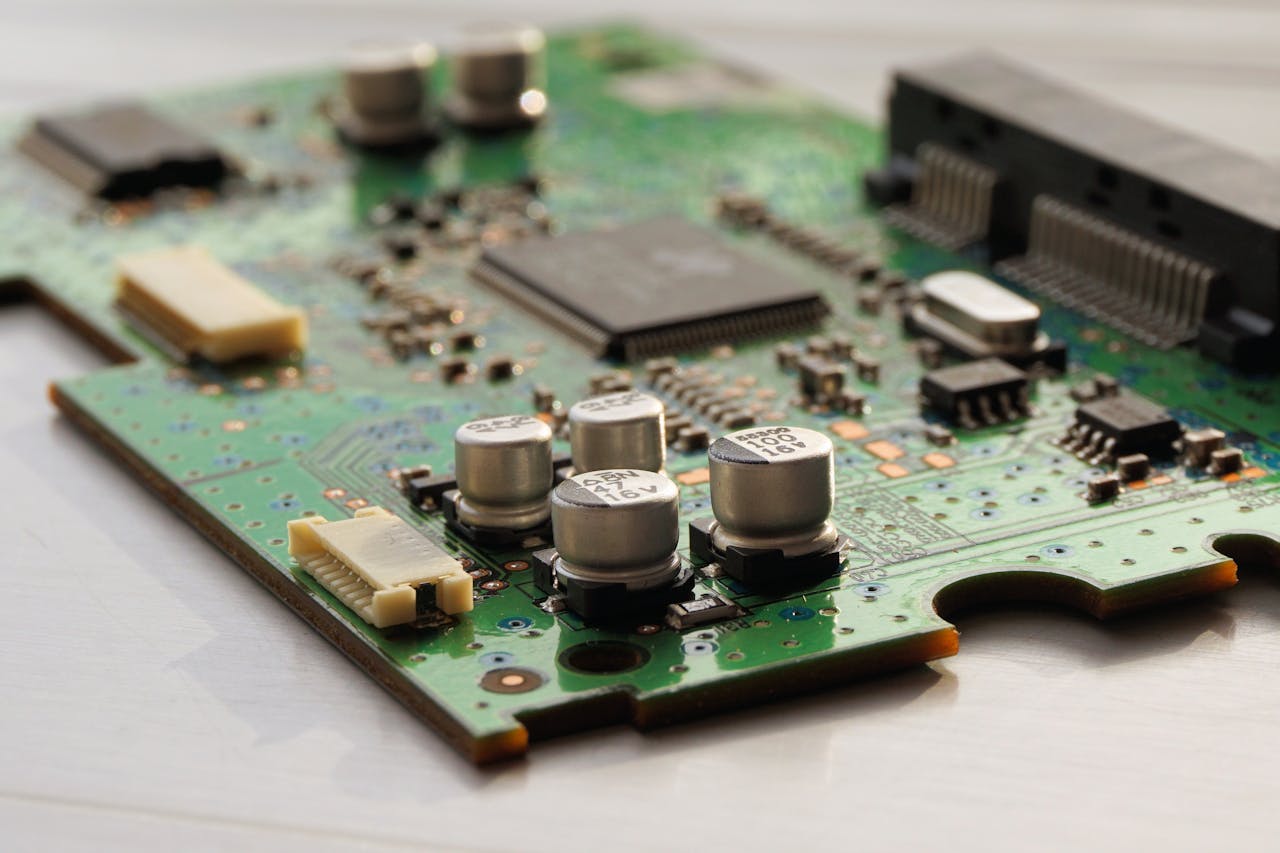 about-01 Detailed view of a green circuit board featuring capacitors and microchips.