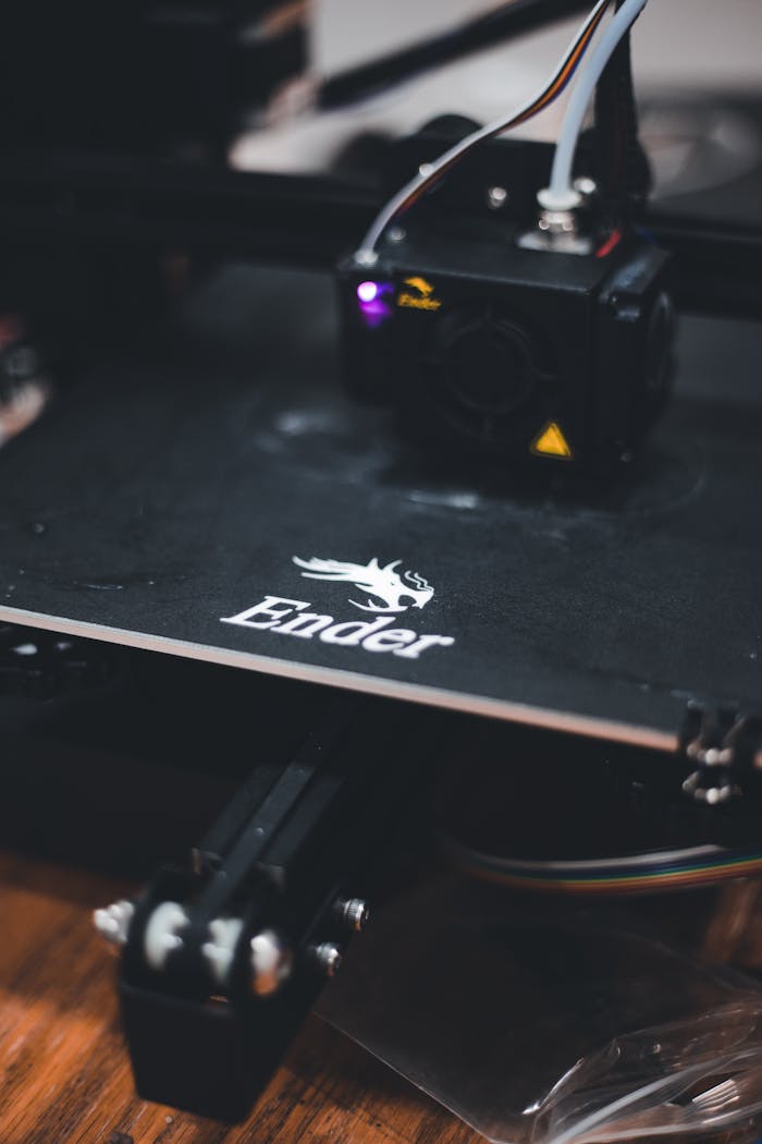 hero-img-02 Detailed view of a 3D printer working on a design with the Ender brand logo visible.